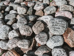 Tas de galets couverts de signatures et d’inscriptions laissées par des visiteurs à Saint-Élie-de-Caxton.